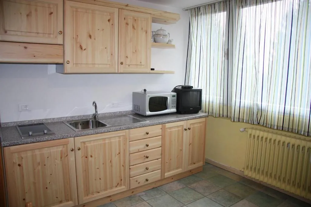Cucina in legno di pino con lavello, piano cottura, microonde e tostapane