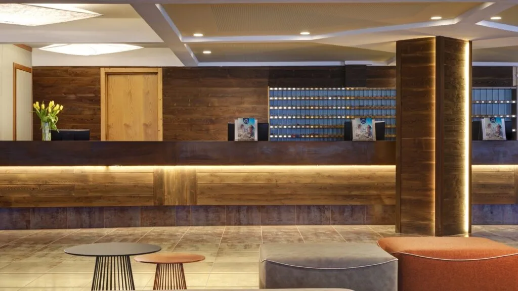 Reception dell'hotel con banco in legno e illuminazione moderna