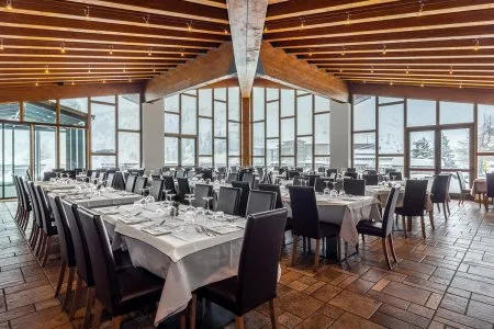 Sala da pranzo con tavoli apparecchiati e grandi vetrate panoramiche