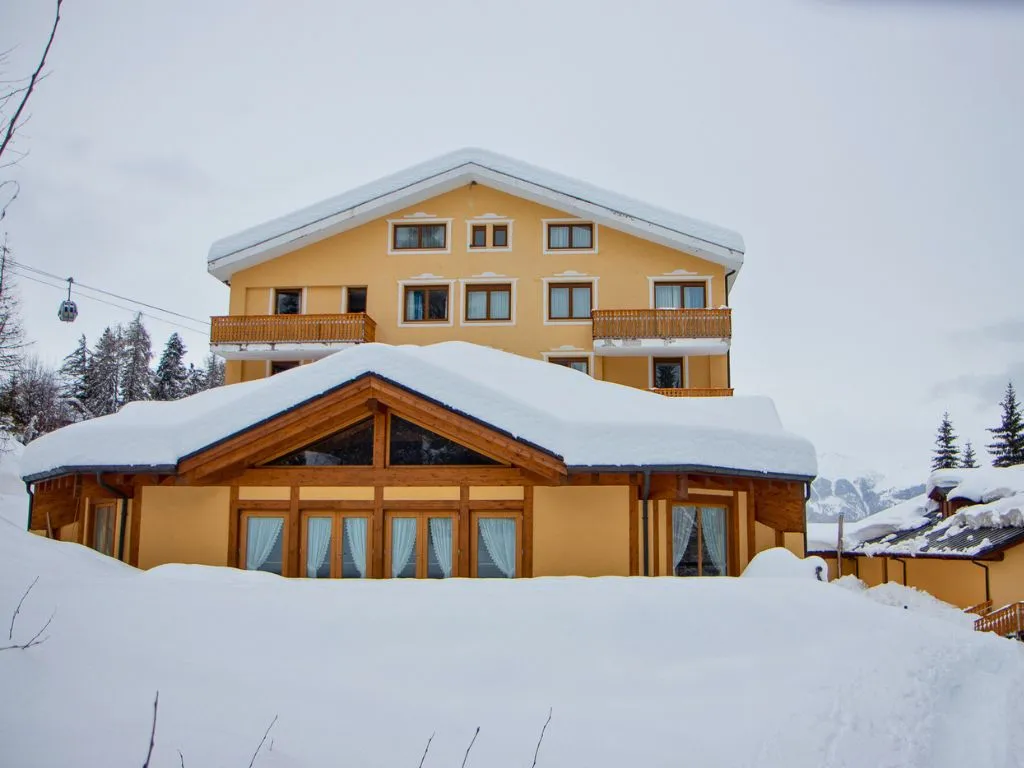 Facciata dell'hotel innevata in inverno con tetti coperti di neve