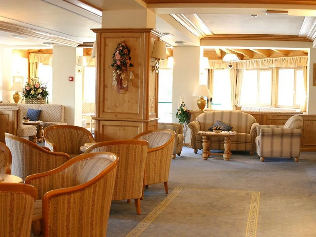 Hall dell'hotel con poltrone imbottite, divani e arredi in legno chiaro