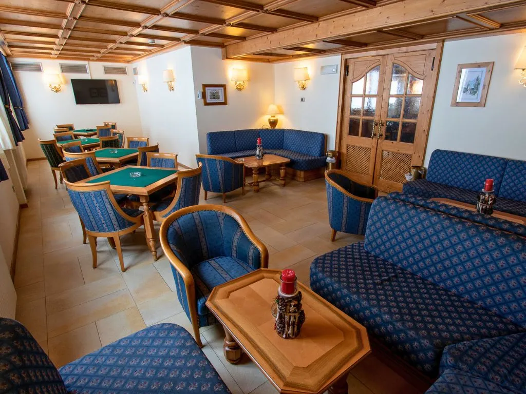 Sala soggiorno con divani blu, tavoli da gioco e arredi in legno