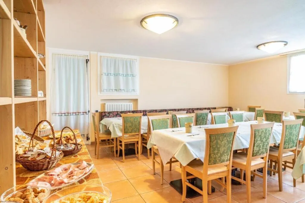 Sala colazione con buffet di pane e affettati e tavoli apparecchiati