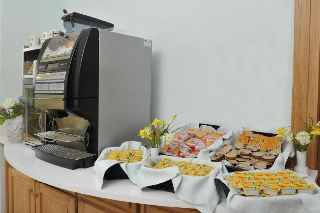 Angolo colazione con macchina del caffè, biscotti e yogurt confezionati