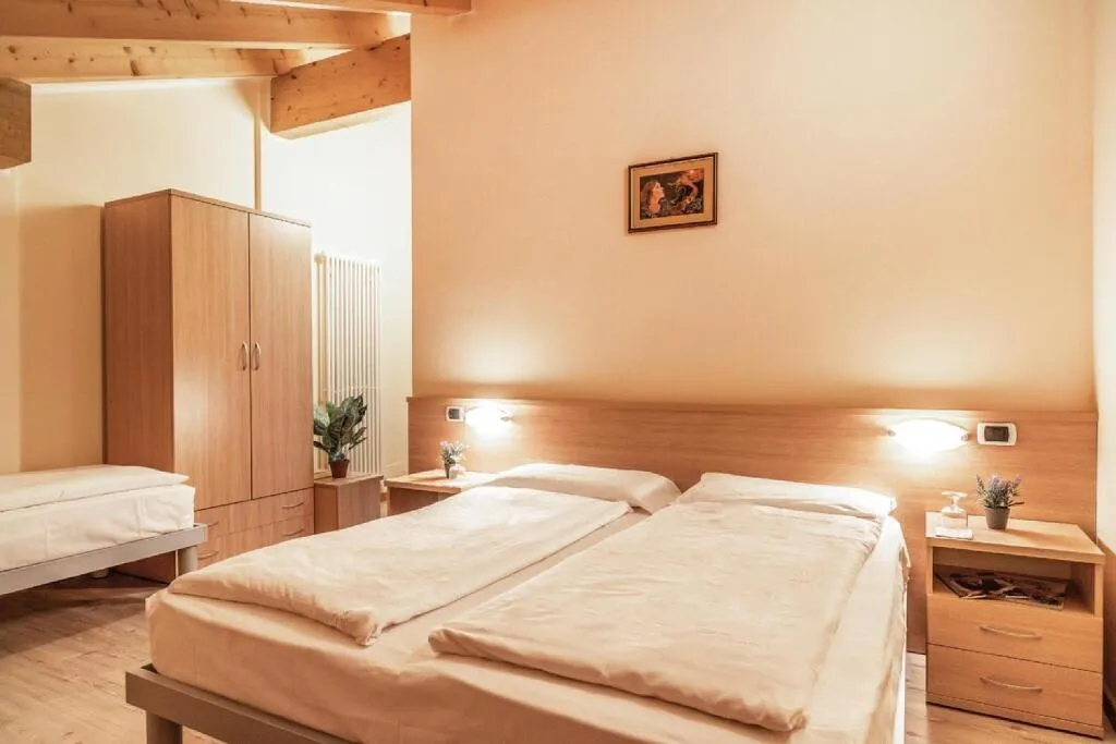Camera con letto matrimoniale, armadio in legno e travi a vista
