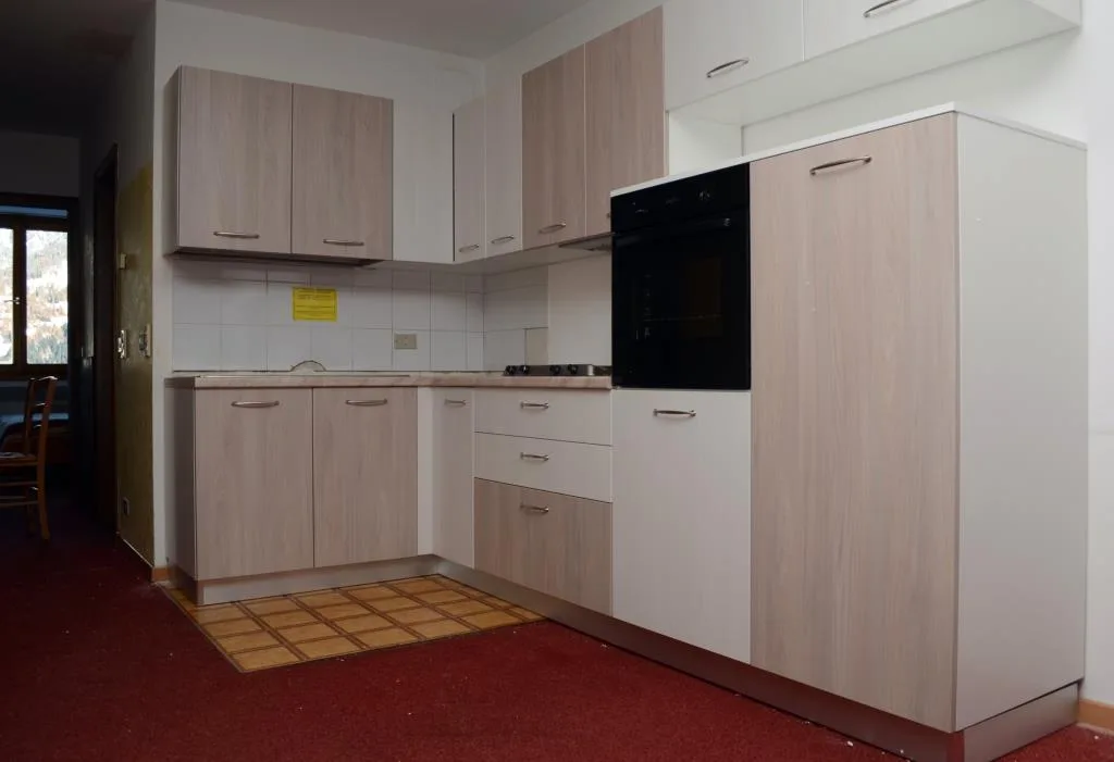 Cucina moderna angolare in legno chiaro con forno e piano cottura