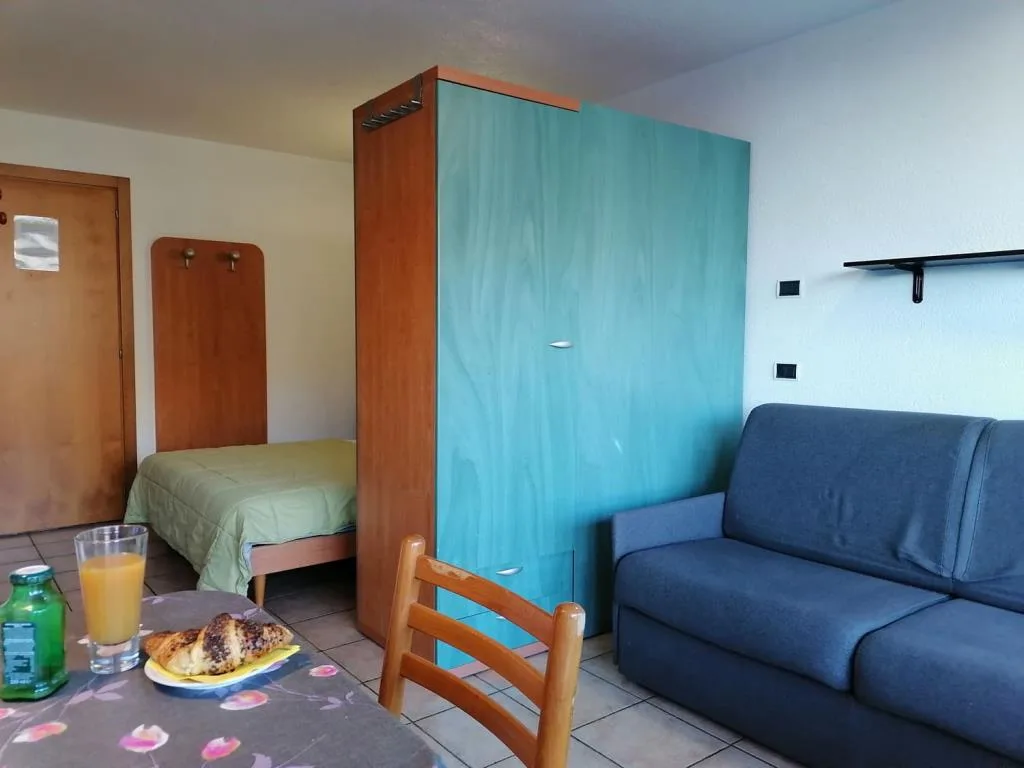 Monolocale con letto singolo, armadio azzurro e divano blu
