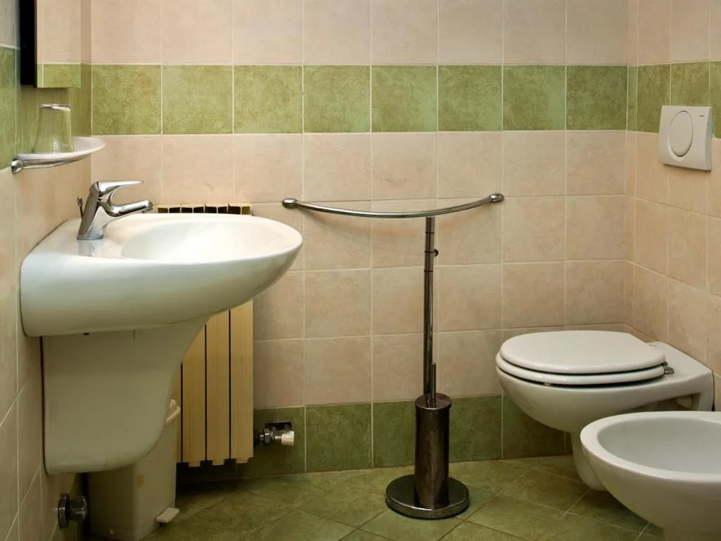 Bagno con lavabo, wc e bidet e piastrelle verdi e beige